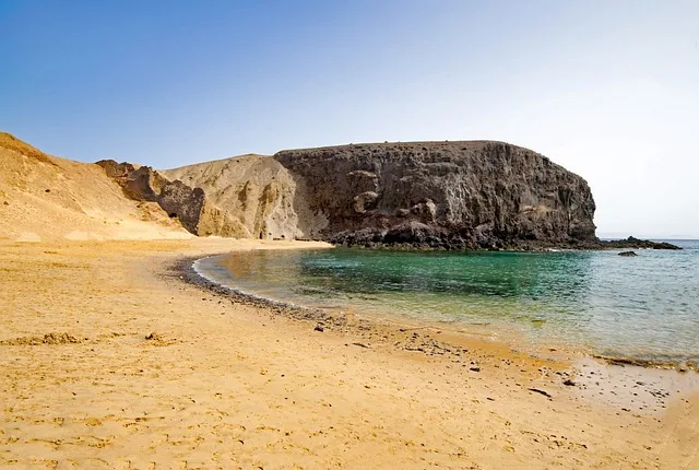 Den lune bukta ved Playa de Papagayo med gule klipper