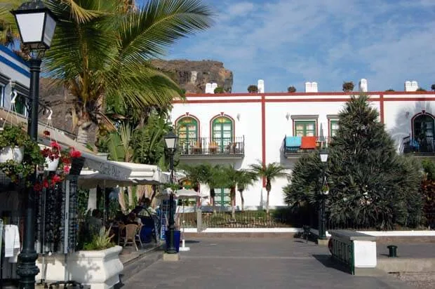 Strandpromenaden i Puerto de Mogán med palmer og hvite hus
